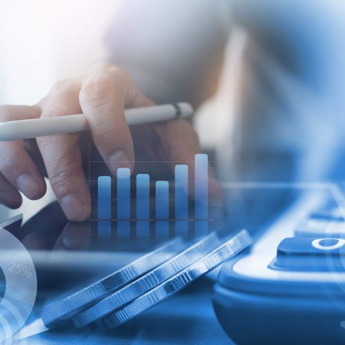 Business analysis, accounting and finance investment concept. Double exposure of business man working on digital tablet and coins with digital diagram, business data, financial graph